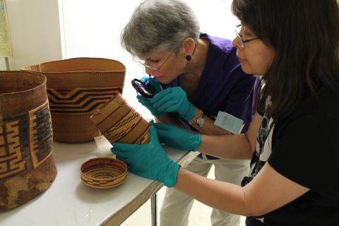 Marjorie Peterson and Daphne Wright Closely Inspecting Baskets